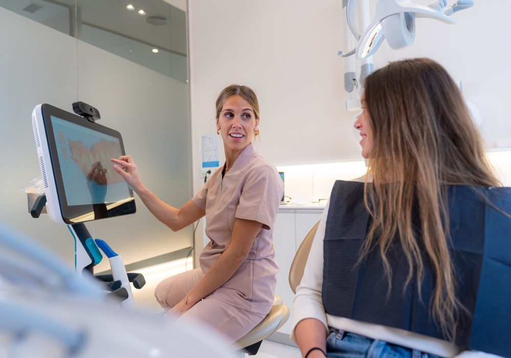 Dentist teaching 3d x-ray x-ray on monitor to young female client in modern dental clinic Dentist teaching 3d x-ray x-ray on monitor to young female client in modern dental clinic
